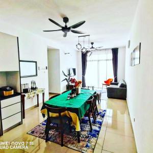 a living room with a green table and a ceiling fan at Ai Qaseh Desaru Penawar Pool Apartment Homestay in Bandar Penawar