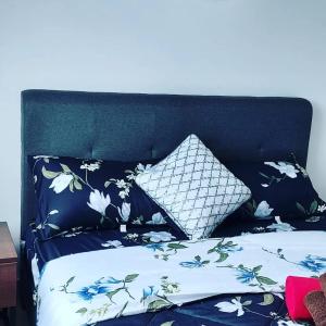 a bed with blue and white sheets and a pillow at Ai Qaseh Desaru Penawar Pool Apartment Homestay in Bandar Penawar