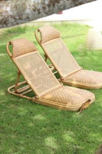 2 chaises en osier assises dans l'herbe dans l'établissement Villa Oceana, Candidasa, à Candidasa
