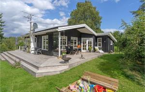 エーベルトフトにあるStunning Home In Ebeltoft With Wifiの木製デッキ付きの小さな黒い家