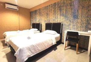 a hotel room with two beds and a chair at OYO HOME 90667 Chen Room Bs in Semporna