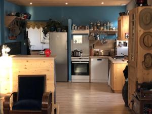uma cozinha com um frigorífico e uma mesa com uma cadeira em Gite, l'Epicerie d'Epreville em Épreville-en-Roumois