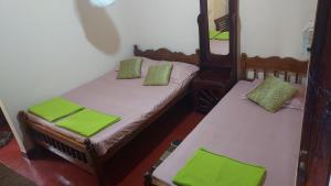 - 2 lits dans une chambre avec des oreillers verts dans l'établissement Green House, à Nallathanniya