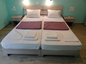 twee bedden in een kamer met handdoeken erop bij Faros apartment in Sfakia