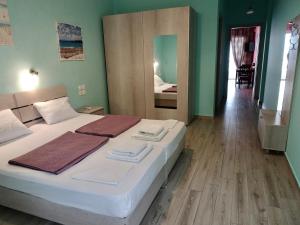 - une chambre avec un lit doté de draps blancs et d'un miroir dans l'établissement Faros apartment, à Sfakiá