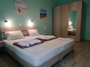 Cette chambre comprend un grand lit blanc et un miroir. dans l'établissement Faros apartment, à Sfakiá