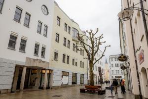Leute gehen eine Stadtstraße mit Gebäuden entlang in der Unterkunft BONNYSTAY Passau Downtown - mitten in der Altstadt Passau`s in Passau