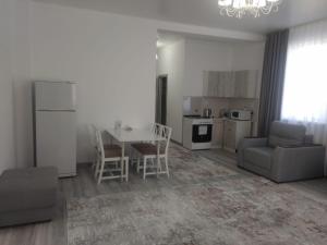 a kitchen and living room with a table and chairs at Апарт отель Welcome in Taldykorgan