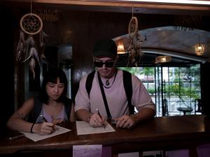 a man and a woman sitting at a table writing at WHITE BANANA Manila - NEW in Manila