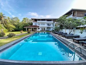 uma imagem de uma piscina em frente a uma casa em Villa Kaya Guest House em Hikkaduwa