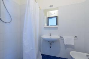 a white bathroom with a sink and a mirror at Hotel Paloma in Rimini