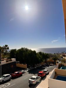 una vista de una calle con coches aparcados y el océano en Casa Jerome, en Playa Paraiso