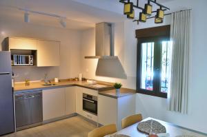 a kitchen with white cabinets and a table and a window at Casa Limon, Patio y Parking. in Granada