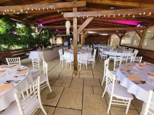 a set up for a wedding reception in a barn with white tables and chairs at Hotel Glamour in Kaluža