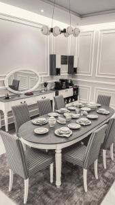 a dining room table with chairs and a kitchen at سيلينا هاوس in Jeddah