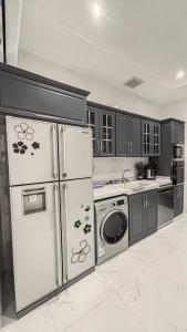 a kitchen with a refrigerator and a washing machine at سيلينا هاوس in Jeddah