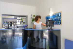 Una donna in piedi dietro un bancone in una cucina di Hotel Paloma a Rimini