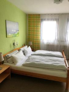 a large bed in a bedroom with a window at Pension Stauber in Hohenburg