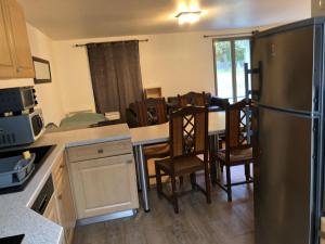 eine Küche mit Kühlschrank und einem Tisch mit Stühlen in der Unterkunft Maison Proche Chartres 5 LITS PARKING in Chartres