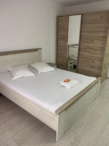 1 dormitorio con 1 cama blanca grande y espejo en Cazare bloc nou ultracentral, en Râmnicu Vâlcea