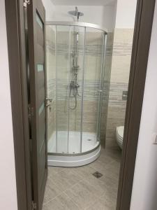 a glass shower in a bathroom with a toilet at Cazare bloc nou ultracentral in Râmnicu Vâlcea