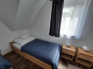 Habitación pequeña con cama y ventana en Panka Üdülőház-Bónom zug, en Gyomaendrőd