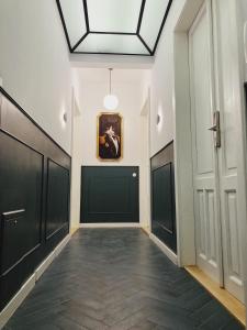 a hallway with black doors and a painting on the wall at Apartament na Krakowskim Kazimierzu in Krakow