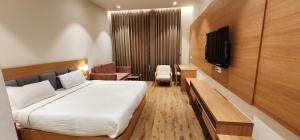 Hotel Gorbandh في أودايبور: غرفه فندقيه سرير وتلفزيون