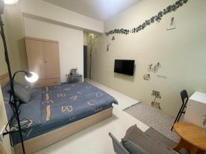 um quarto com uma cama e uma televisão em Candy House em Zhushan