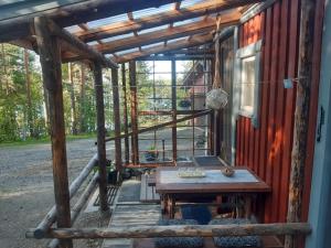 eine Veranda einer Hütte mit einem Holztisch in der Unterkunft Rantakallio Savonlinna, Tervetuloa meille! in Savonlinna