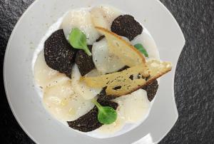 a white plate of food on a table at Domaine du Bugassou, Chambres, Table d'hôtes & SPA in Belvès