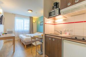 a small room with a bed and a kitchen at Appart'City Classic La Roche sur Yon Centre in La Roche-sur-Yon