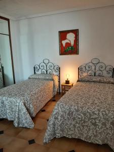 - une chambre avec 2 lits et une photo sur le mur dans l'établissement Horizontes de La Mancha, à El Toboso