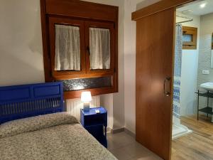 a bedroom with a blue bed and a wooden cabinet at Horizontes de La Mancha in El Toboso