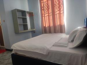 a bed in a room with a window at RS #10selous in Ukaranga