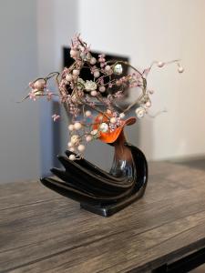 a black vase with flowers in it on a table at LuanaApartments # 43 in Otopeni