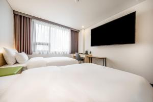 Jamsil Stay Hotel في سول: غرفة فندقية بسرير وتلفزيون بشاشة مسطحة