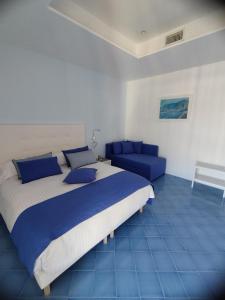 um quarto com uma cama grande e um sofá em Domus Sole em Sorrento
