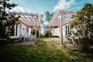 a pergola and a table and chairs in a yard at Camping Molo Surf SPOT in Jastarnia