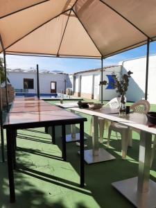 a patio with a table and chairs under an umbrella at Horizontes de La Mancha in El Toboso