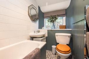 a bathroom with a toilet and a sink and a tub at Hideaway country cottage near Edinburgh in Penicuik