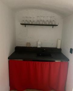 フルバー・スカーラにあるApartmán Doubraviceの赤いカーテンと棚の上のグラス付きカウンター