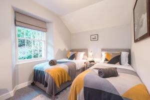 two beds in a room with a window at Hideaway country cottage near Edinburgh in Penicuik