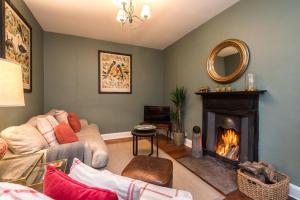 a living room with a couch and a fireplace at Hideaway country cottage near Edinburgh in Penicuik