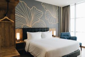 a bedroom with a bed and a blue chair at Grand Central Premier Medan in Medan