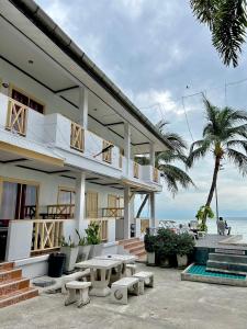 a white building with a picnic table and the ocean at Rin Bay View Resort in Haad Rin
