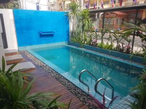 a swimming pool in a building with a blue wall at Baahu Villa in Siem Reap