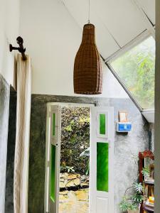a room with a door and a pendant light at Moksha eco villa Ella in Ella