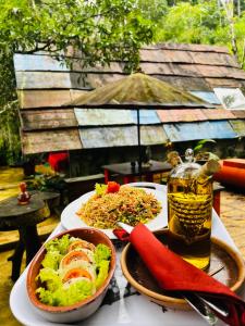 a table with two plates of food and a drink at Moksha eco villa Ella in Ella