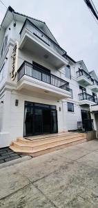 biały budynek z drewnianymi schodami przed nim w obiekcie MONACO HOTEL w mieście Khu Chi Lăng